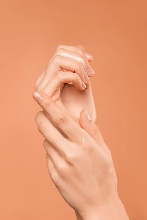 nourishing dry skin A person’s hands on an orange background