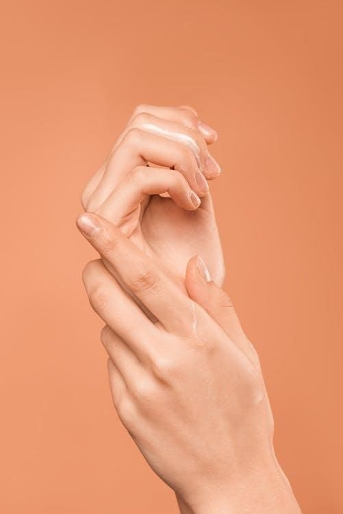 A person’s hands on an orange background