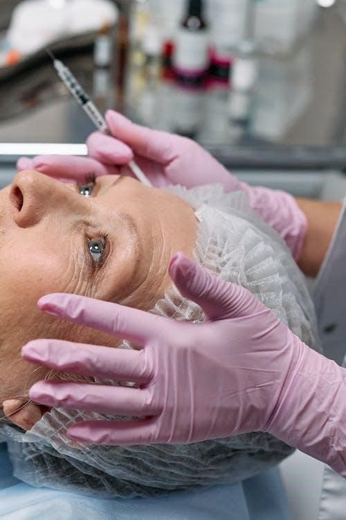 A woman wearing a cap in a skincare facility getting anti-aging treatment 